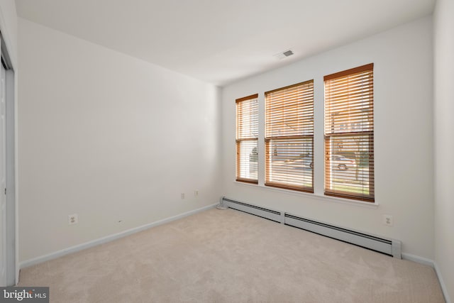 carpeted empty room featuring a baseboard radiator