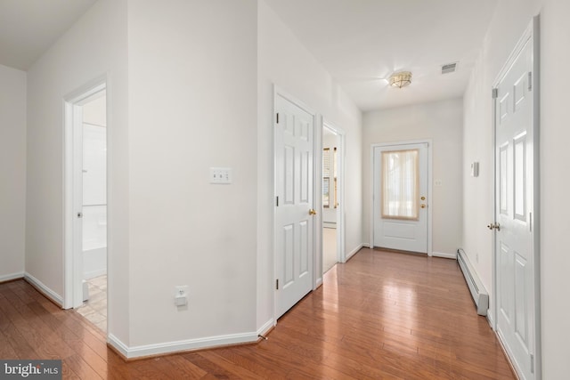 interior space with a baseboard radiator and light hardwood / wood-style flooring