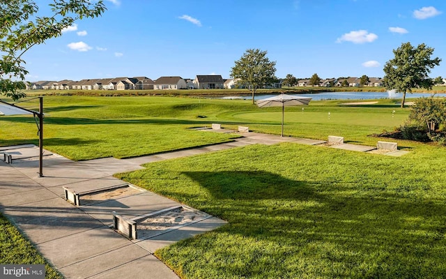 view of home's community with a water view and a yard