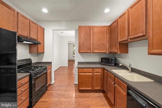 kitchen featuring sink, light hardwood / wood-style floors, and black appliances