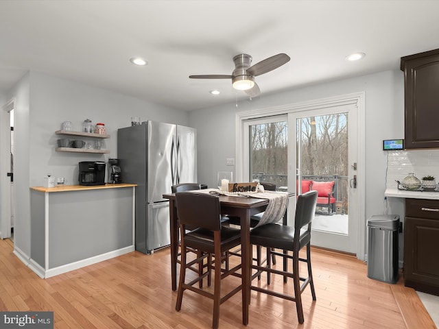 dining space with ceiling fan and light hardwood / wood-style flooring