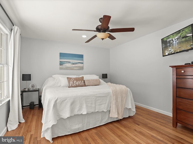 bedroom featuring light wood-type flooring, ceiling fan, and multiple windows