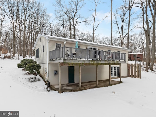 snow covered house featuring a wooden deck