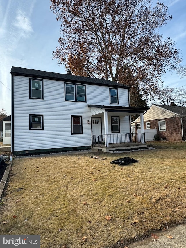 view of property featuring covered porch and a front yard