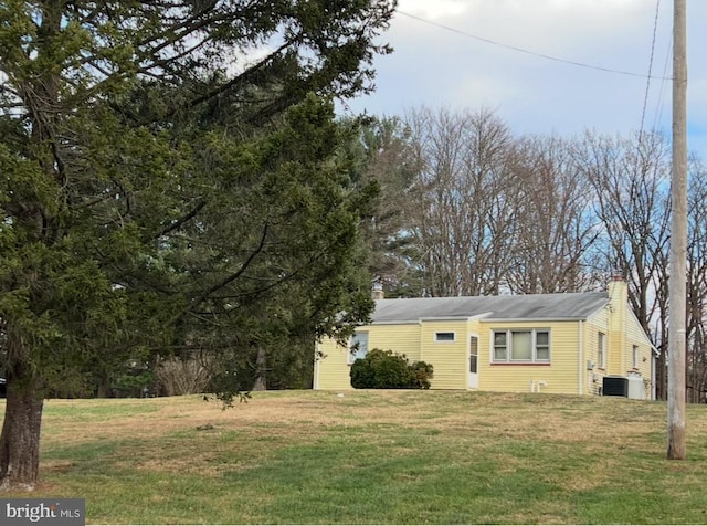 view of front of property with central AC unit and a front lawn