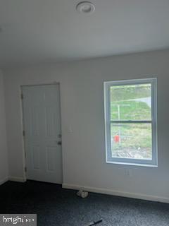 454 Roundview Rd, Baltimore, MD 21225 - unfurnished room featuring baseboards and dark colored carpet