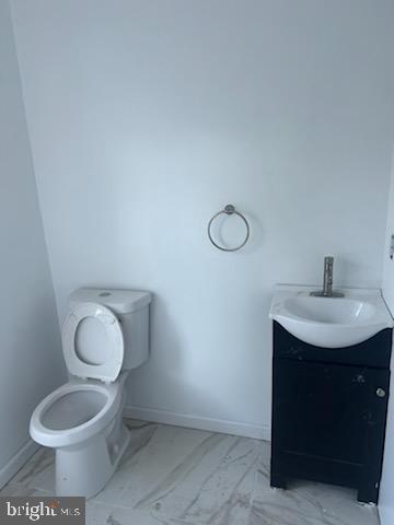 454 Roundview Rd, Baltimore, MD 21225 - bathroom featuring marble finish flooring, vanity, toilet, and baseboards