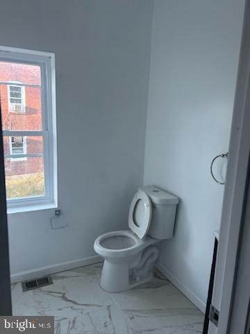 454 Roundview Rd, Baltimore, MD 21225 - bathroom with marble finish floors, toilet, baseboards, and plenty of natural light