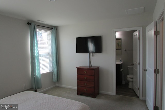 carpeted bedroom featuring ensuite bath