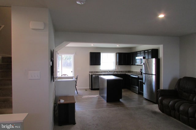 kitchen featuring sink, hardwood / wood-style floors, a kitchen island, and appliances with stainless steel finishes