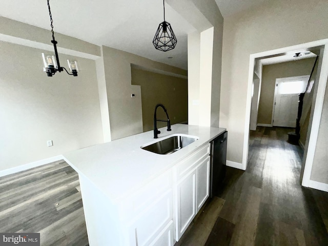 kitchen featuring sink, dishwasher, a kitchen island with sink, hanging light fixtures, and white cabinetry