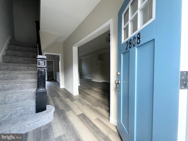 interior space with hardwood / wood-style flooring and vaulted ceiling