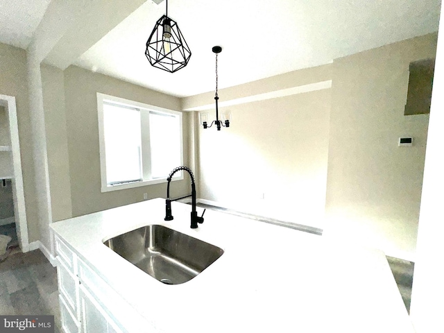 kitchen with pendant lighting, sink, and white cabinets