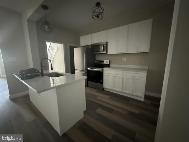 kitchen with white cabinets, appliances with stainless steel finishes, hanging light fixtures, and sink