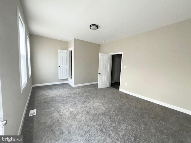 unfurnished bedroom with dark carpet