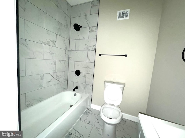 bathroom with tiled shower / bath and toilet