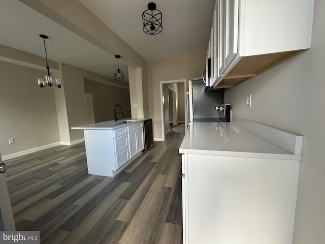 kitchen with sink, black dishwasher, kitchen peninsula, pendant lighting, and white cabinets