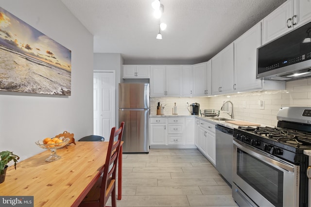 3701 S George Mason Dr Unit 1005N, Falls Church, VA 22041 - kitchen with decorative backsplash, a sink, light countertops, white cabinets, and stainless steel appliances