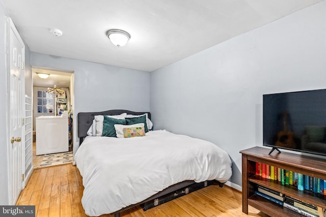 bedroom with washer / clothes dryer and hardwood / wood-style flooring