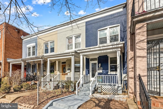 townhome / multi-family property featuring covered porch