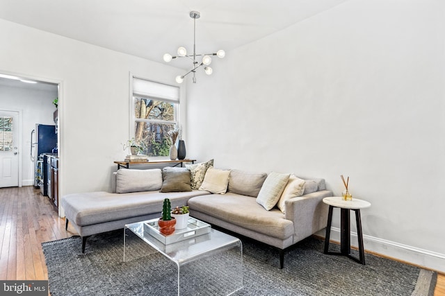 living room with hardwood / wood-style flooring and a notable chandelier