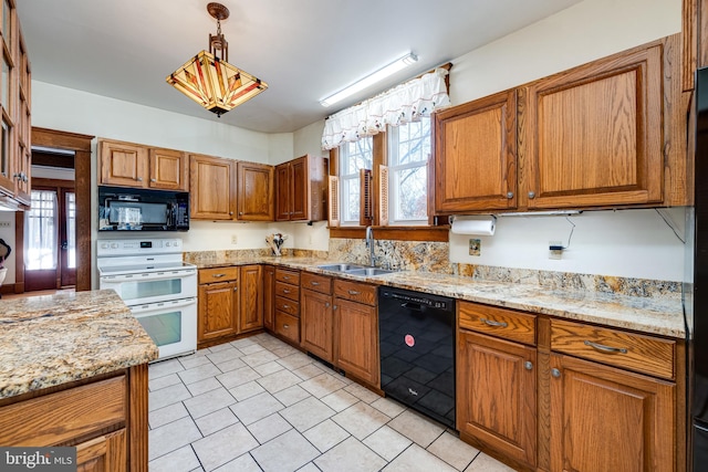 kitchen with light stone countertops, sink, black appliances, and decorative light fixtures