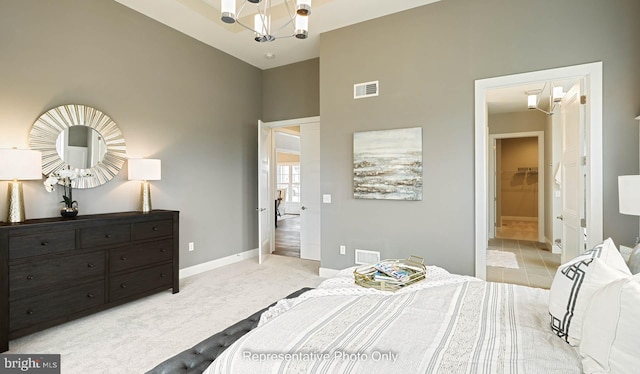 carpeted bedroom with a chandelier and a high ceiling