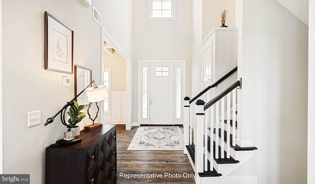 entrance foyer with dark hardwood / wood-style flooring and high vaulted ceiling