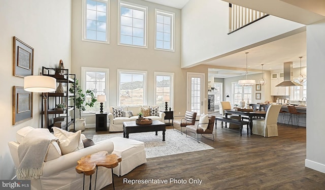 living room featuring a towering ceiling and dark wood-type flooring