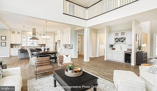 living room with wood-type flooring, wine cooler, and bar area