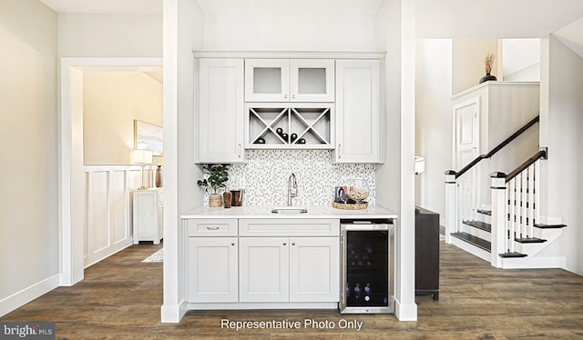 bar featuring dark hardwood / wood-style floors, white cabinetry, sink, and beverage cooler