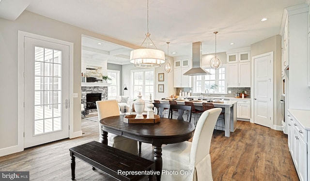 dining area with hardwood / wood-style flooring and a stone fireplace