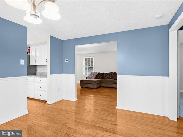 interior space featuring a chandelier, a textured ceiling, and light hardwood / wood-style floors