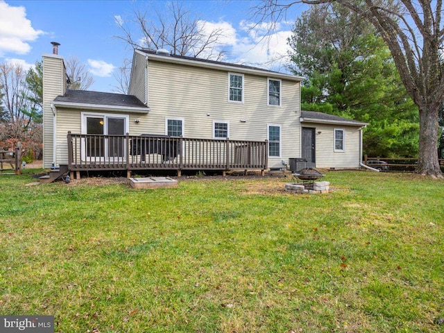 rear view of house featuring a lawn, a deck, an outdoor fire pit, and central air condition unit