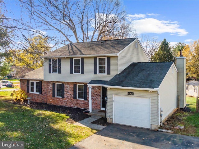 view of property featuring a front yard and a garage