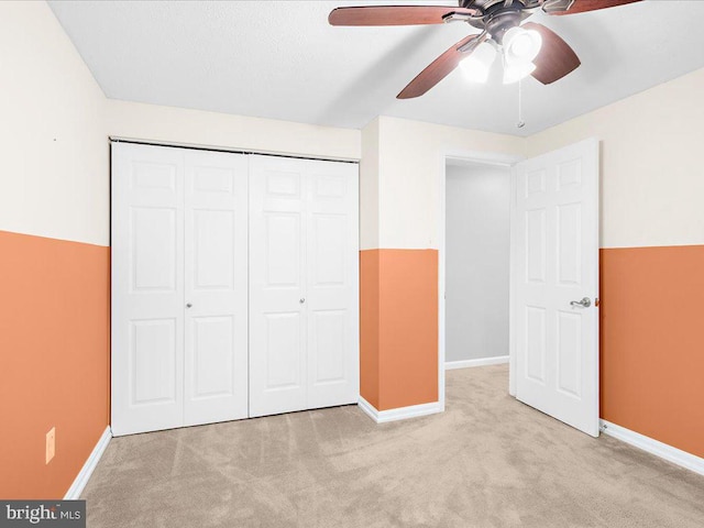 unfurnished bedroom with light carpet, a closet, and ceiling fan