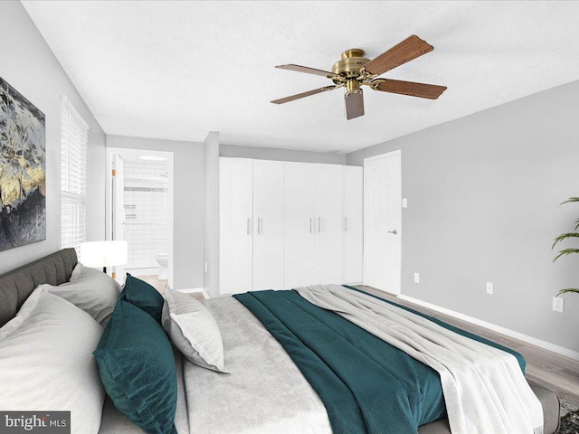 bedroom with hardwood / wood-style flooring, ceiling fan, a textured ceiling, and ensuite bath