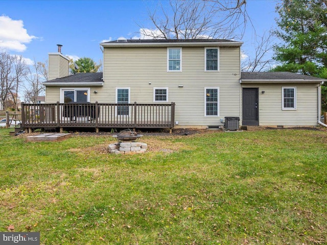 rear view of property with a lawn, a deck, and an outdoor fire pit