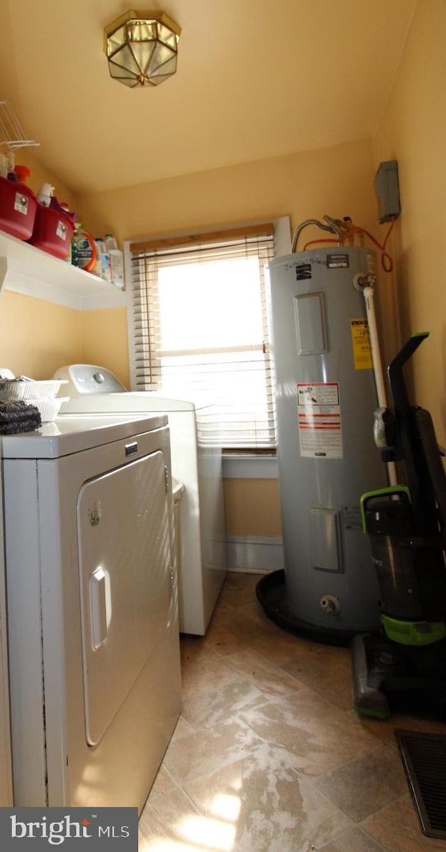 washroom featuring electric water heater and washer and clothes dryer