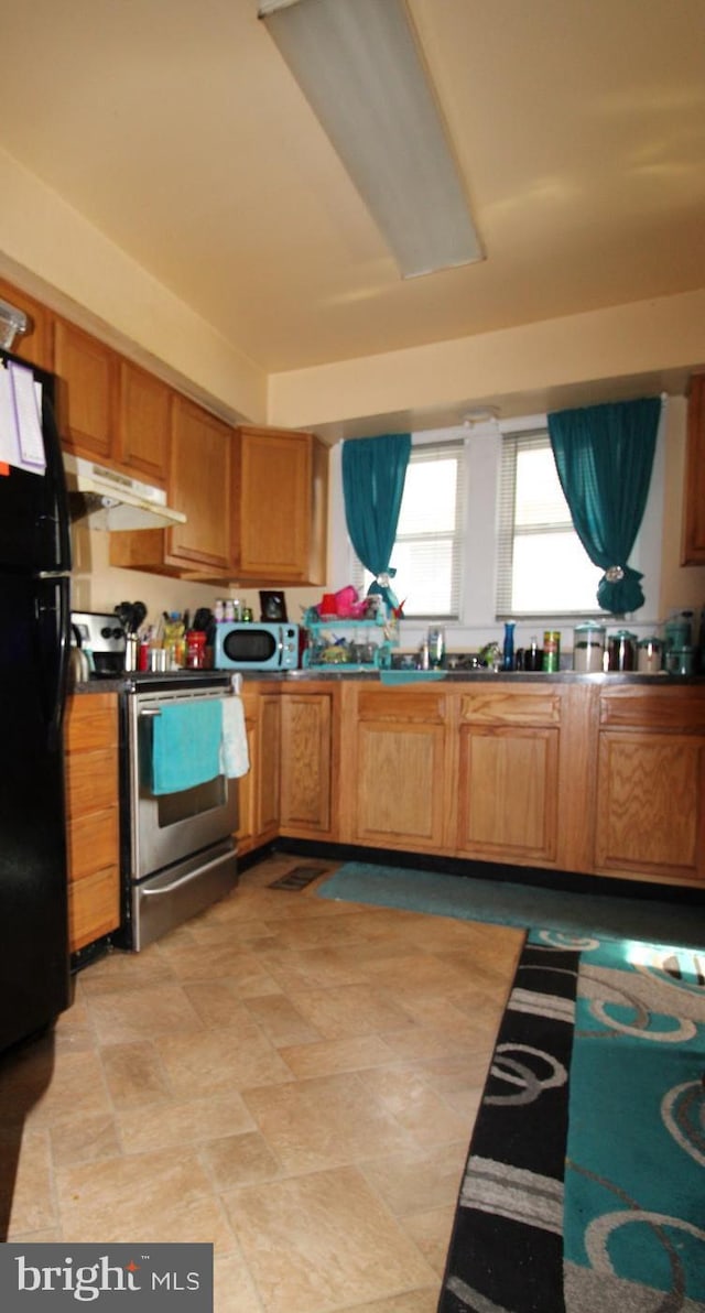 kitchen featuring stainless steel electric stove and black fridge