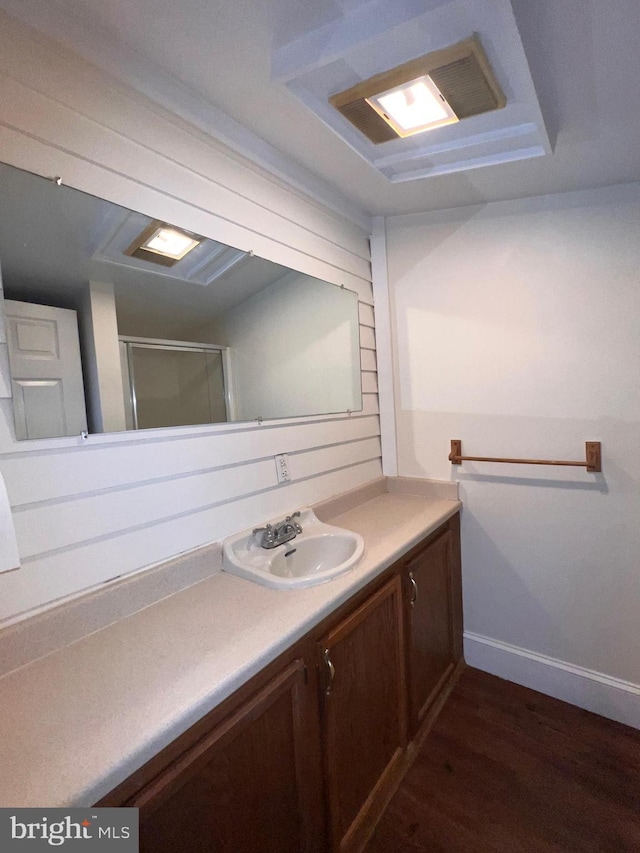 bathroom with hardwood / wood-style floors, vanity, and walk in shower