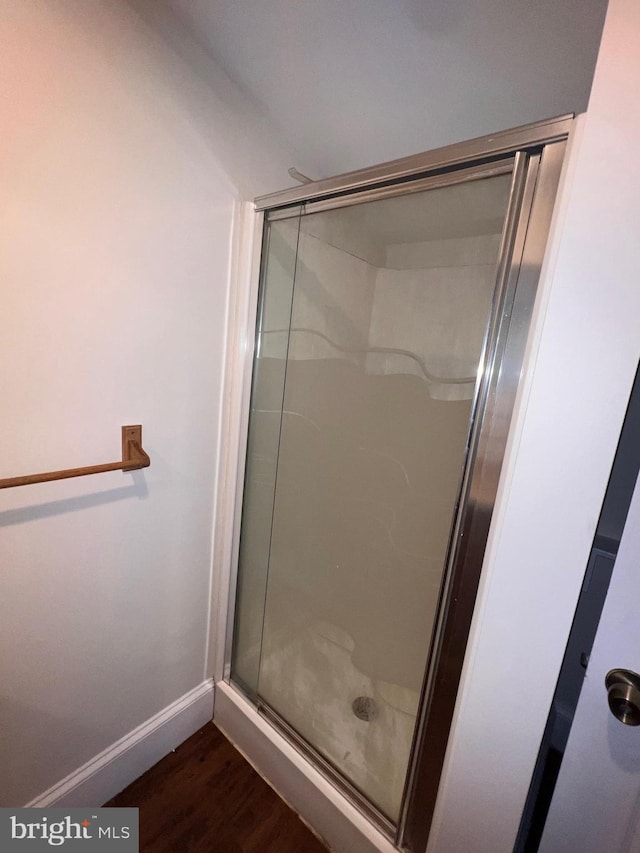 bathroom featuring wood-type flooring and walk in shower