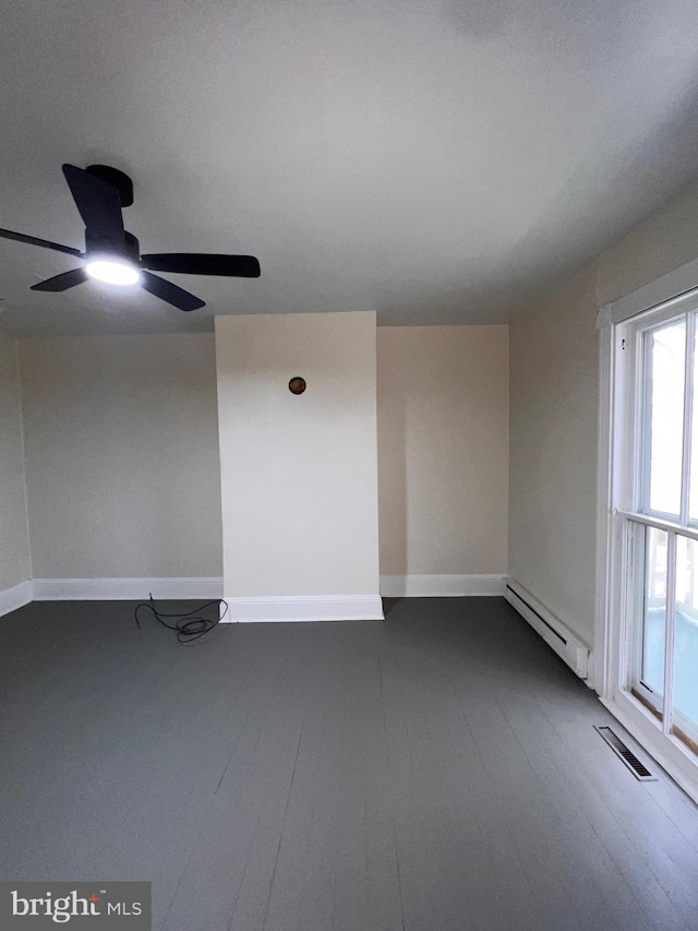 unfurnished room featuring dark hardwood / wood-style flooring, baseboard heating, and ceiling fan