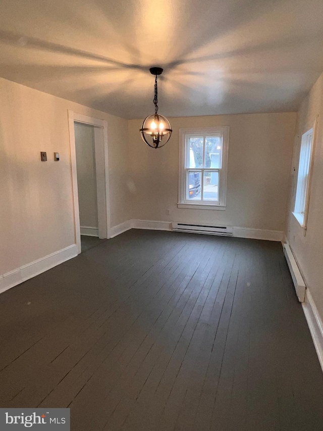 unfurnished room featuring dark hardwood / wood-style flooring, baseboard heating, and a notable chandelier