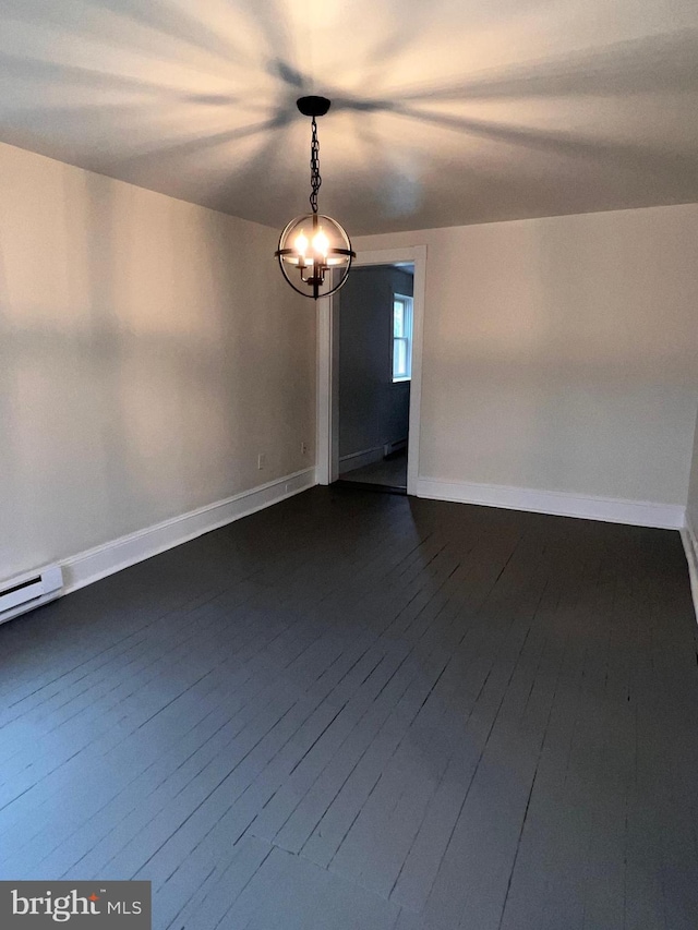 unfurnished room with dark hardwood / wood-style floors, a baseboard heating unit, and an inviting chandelier