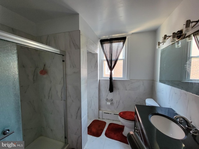 bathroom with toilet, a shower with shower door, tile walls, and a baseboard heating unit