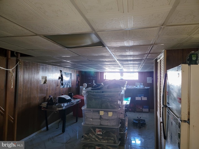 basement with wooden walls and white fridge