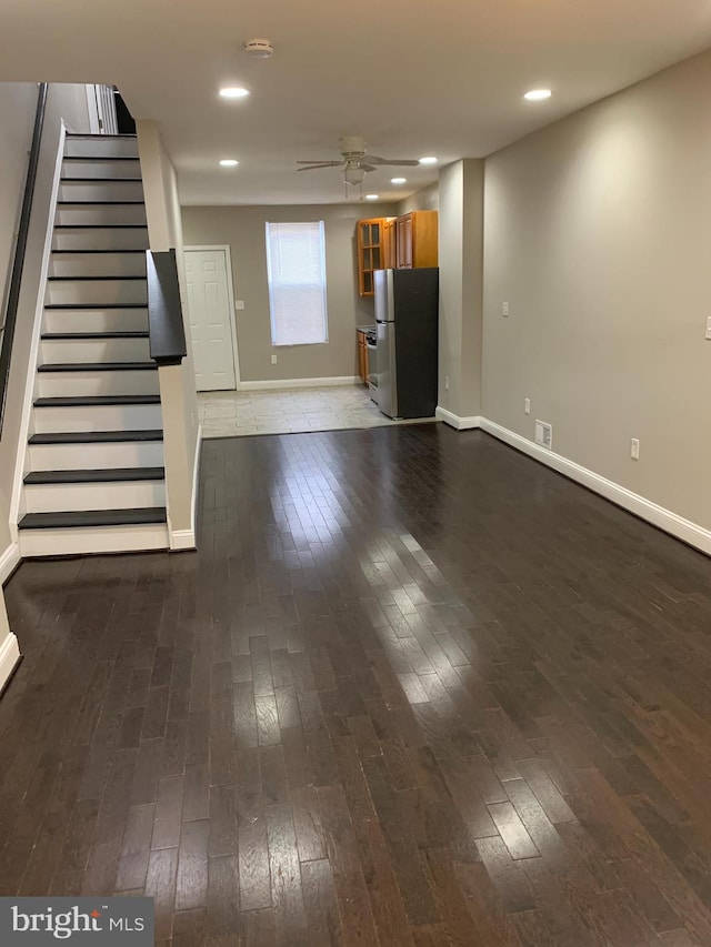 unfurnished living room with wood-type flooring and ceiling fan