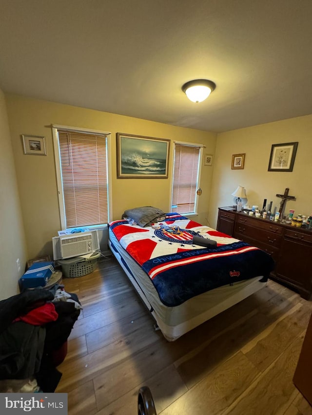 bedroom featuring an AC wall unit and dark wood-type flooring