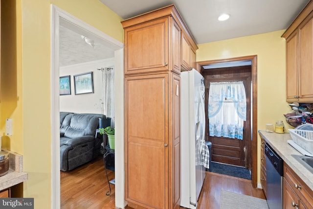 kitchen featuring stainless steel dishwasher, crown molding, white refrigerator with ice dispenser, and dark wood-type flooring